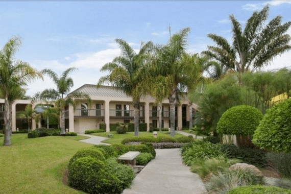 lawn, palm trees, and walking path of Best Western Plus South Coast Inn